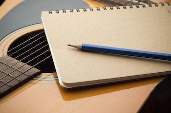 Songwriter's guitar and paper