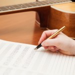 Songwriter with paper and guitar