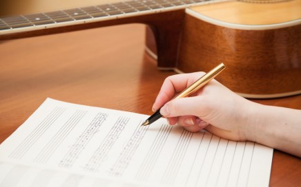 Songwriter with paper and guitar