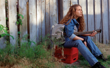 Songwriter outside with guitar